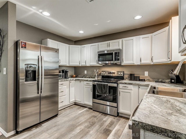 kitchen featuring light hardwood / wood-style flooring, stainless steel appliances, white cabinetry, and sink