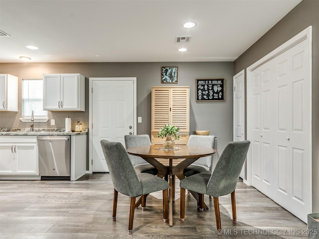 dining space with light hardwood / wood-style flooring and sink