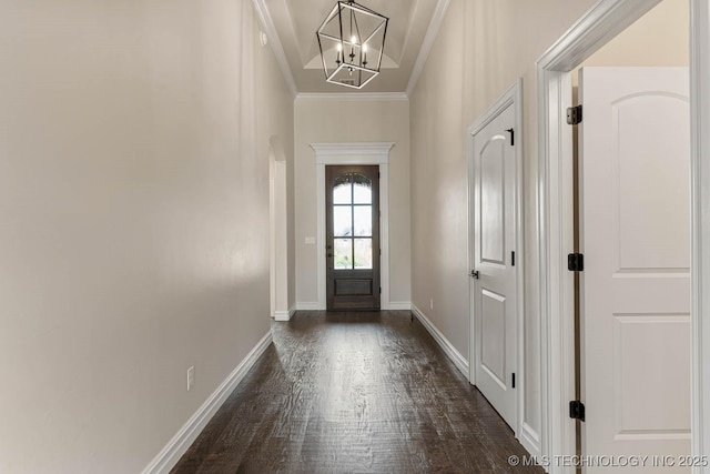 doorway featuring a notable chandelier, dark hardwood / wood-style flooring, and ornamental molding