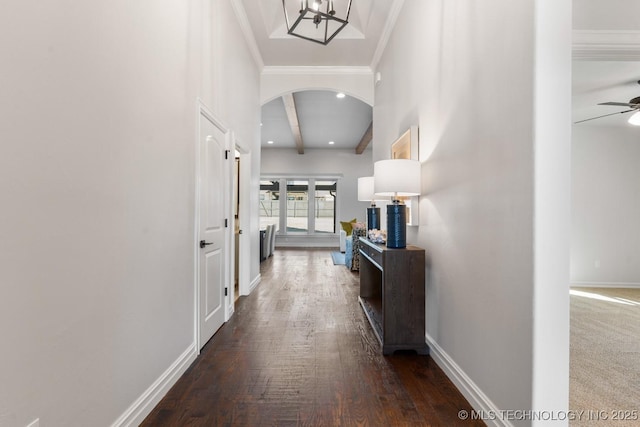 corridor with arched walkways, baseboards, beam ceiling, dark wood-style floors, and crown molding