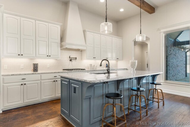 3913 S Dogwood Blvd, Broken Arrow, OK 74012 - kitchen featuring white cabinets, custom range hood, hanging light fixtures, and a center island with sink