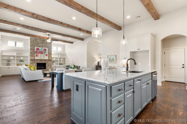 3913 S Dogwood Blvd, Broken Arrow, OK 74012 - kitchen featuring a center island with sink, arched walkways, white cabinets, open floor plan, and a sink
