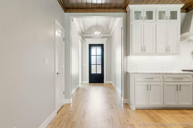 entryway featuring light wood-type flooring, an inviting chandelier, crown molding, and wood ceiling