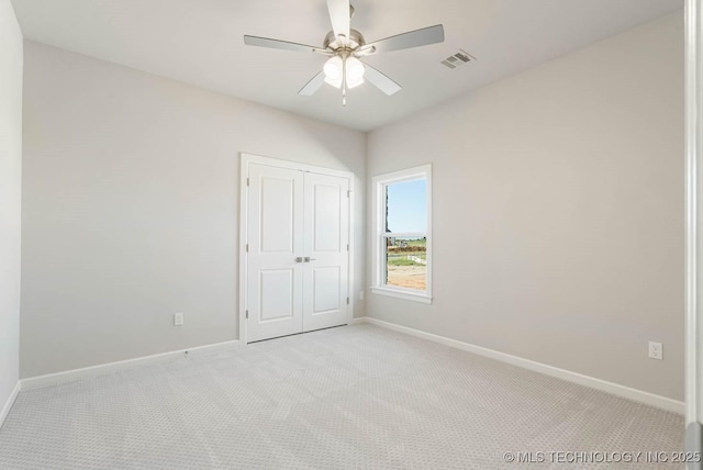 spare room featuring light carpet and ceiling fan