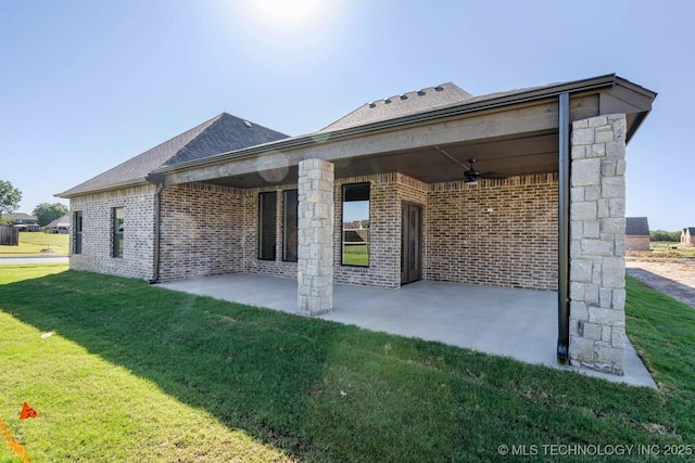 back of house with ceiling fan, a patio area, and a lawn