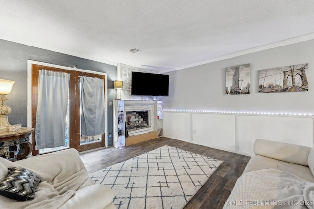 living room with ornamental molding, dark wood-type flooring, and a textured ceiling