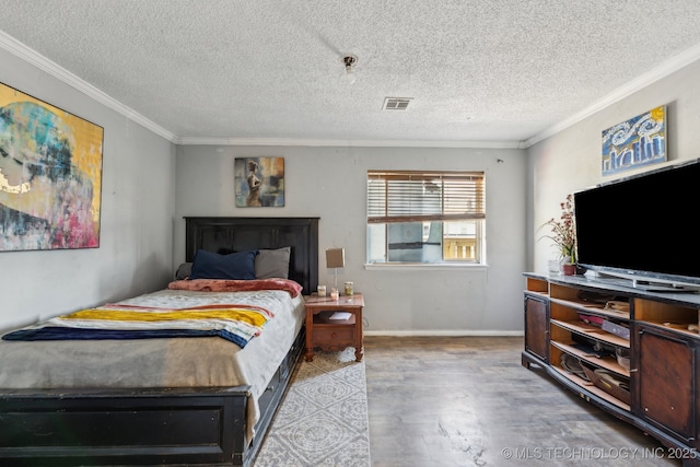 bedroom featuring crown molding, wood-type flooring, and a textured ceiling