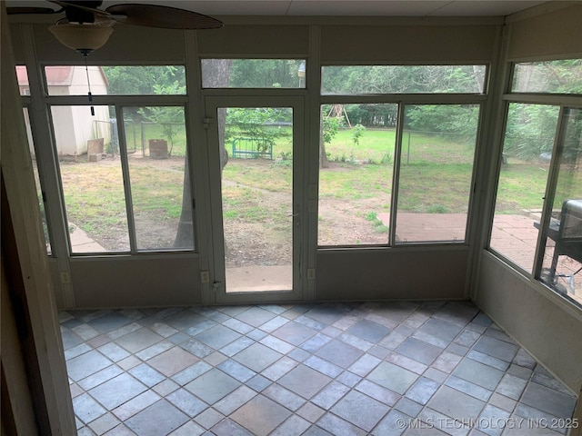 unfurnished sunroom with ceiling fan