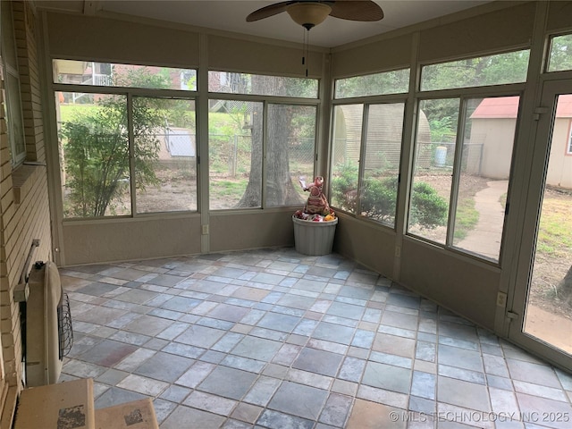 unfurnished sunroom with ceiling fan