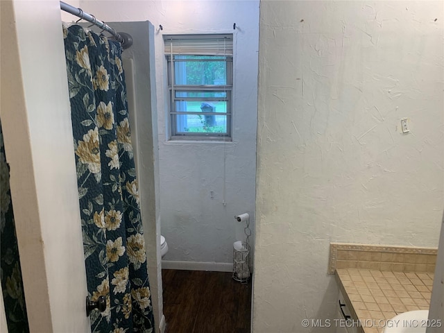 bathroom with toilet and hardwood / wood-style flooring