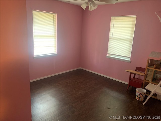 empty room with dark hardwood / wood-style floors and ceiling fan