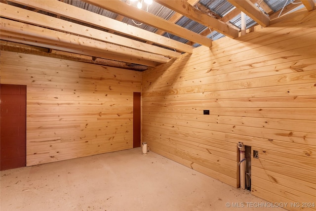 additional living space with wooden walls and concrete floors