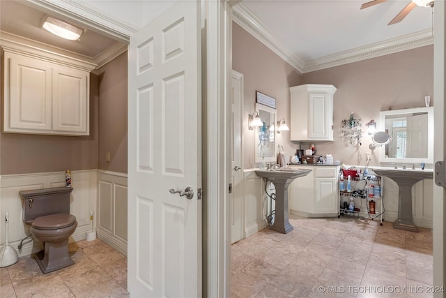 bathroom with toilet, ceiling fan, crown molding, and sink