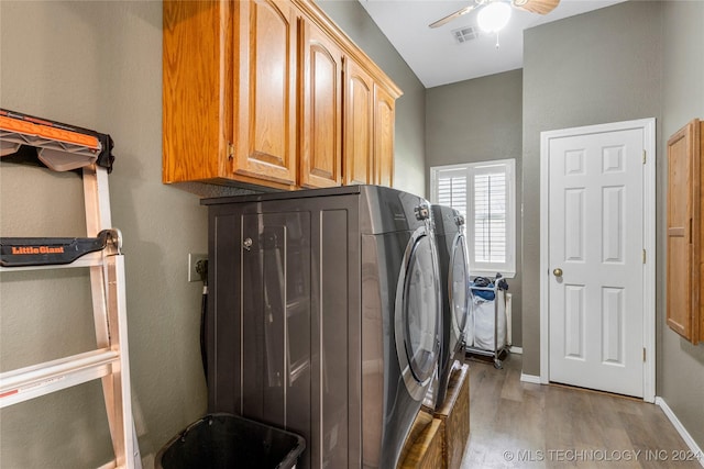 washroom featuring washing machine and clothes dryer, ceiling fan, cabinets, and light wood-type flooring