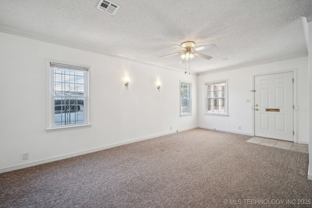 carpeted spare room featuring ceiling fan, crown molding, and a textured ceiling