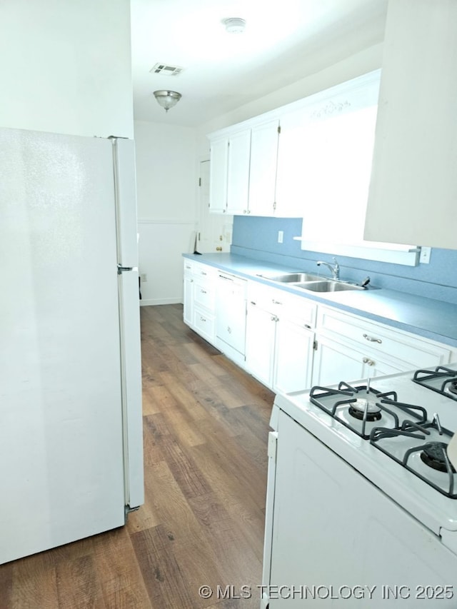 kitchen with white cabinetry, dark hardwood / wood-style flooring, white appliances, and sink