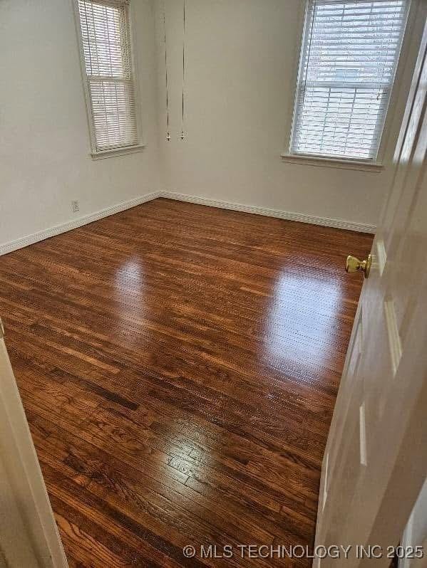 4519 E 5th Pl, Tulsa, OK 74112 - spare room featuring healthy amount of natural light, dark wood-style floors, and baseboards
