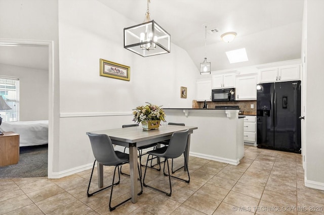 dining room featuring lofted ceiling with skylight, light tile patterned flooring, and a notable chandelier