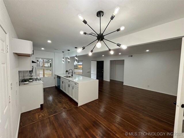 kitchen with white cabinets, decorative light fixtures, an inviting chandelier, and sink