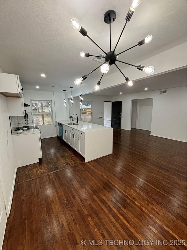 kitchen featuring a kitchen island with sink, sink, pendant lighting, dishwasher, and white cabinetry