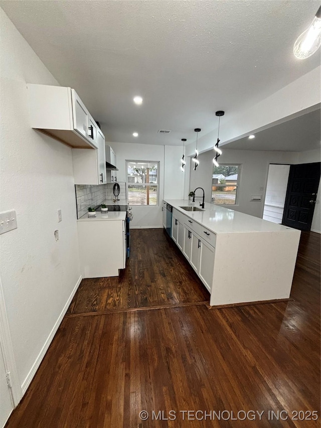 kitchen with sink, white cabinetry, hanging light fixtures, and a kitchen island with sink