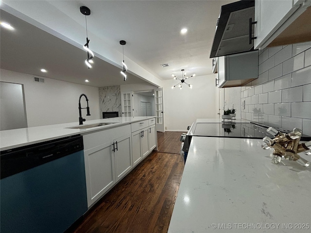 kitchen featuring an inviting chandelier, sink, hanging light fixtures, stainless steel dishwasher, and white cabinetry