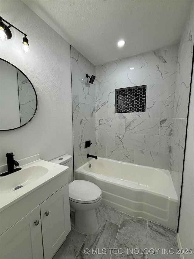 full bathroom featuring toilet, vanity, a textured ceiling, and tiled shower / bath