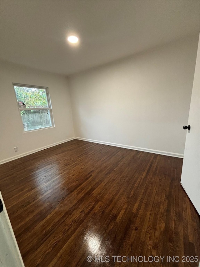 spare room with dark hardwood / wood-style flooring