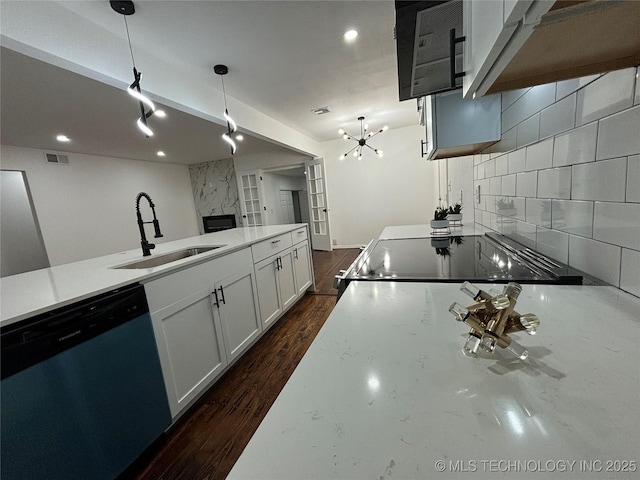 kitchen with pendant lighting, dishwasher, stove, sink, and tasteful backsplash