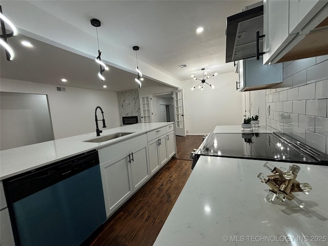 kitchen with sink, stainless steel dishwasher, decorative backsplash, decorative light fixtures, and range