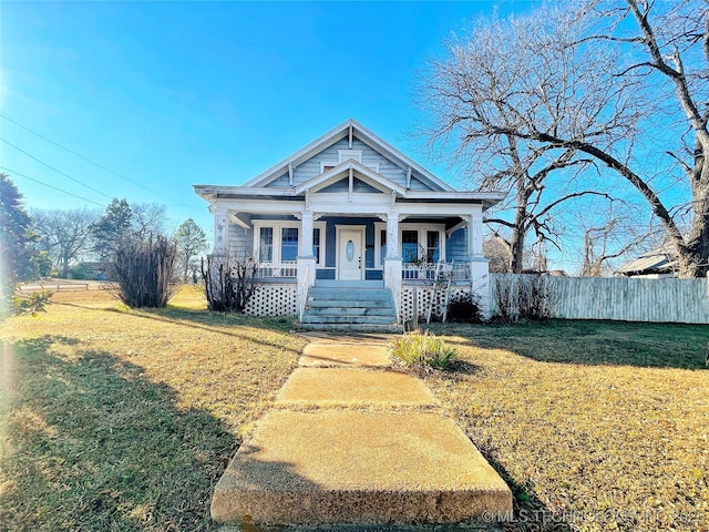 view of front facade featuring covered porch and a front yard