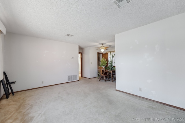 spare room with ceiling fan, light colored carpet, and a textured ceiling