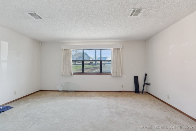 carpeted spare room featuring a textured ceiling