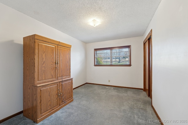 unfurnished bedroom featuring light colored carpet and a textured ceiling