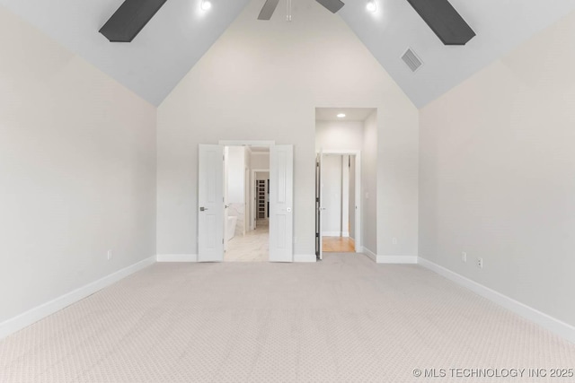 unfurnished bedroom featuring light colored carpet and high vaulted ceiling