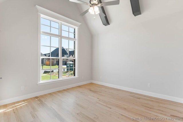 empty room featuring lofted ceiling with beams, a healthy amount of sunlight, and light wood-type flooring