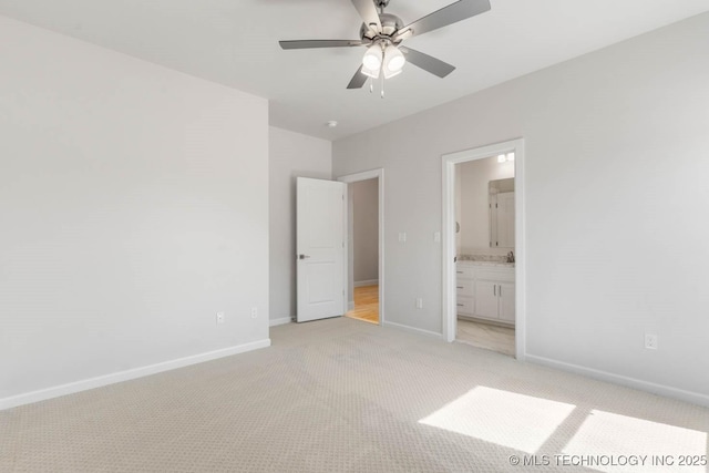 unfurnished bedroom with light carpet, connected bathroom, and ceiling fan