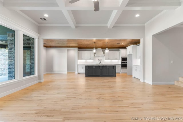 unfurnished living room featuring ceiling fan, crown molding, sink, beam ceiling, and light hardwood / wood-style flooring