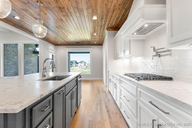 kitchen featuring white cabinets, wooden ceiling, and sink