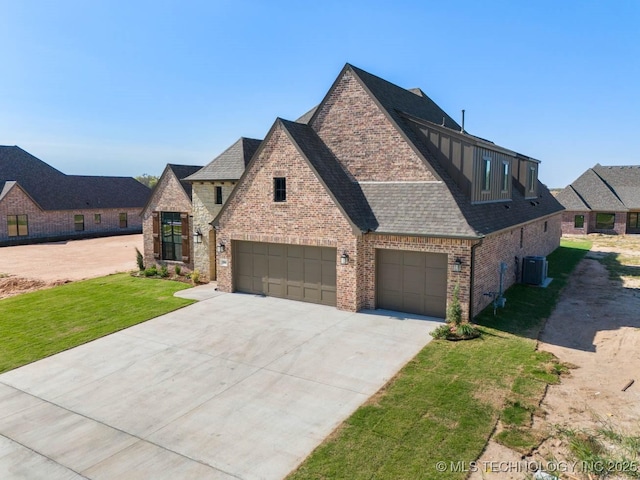 view of front of house featuring a front lawn, cooling unit, and a garage