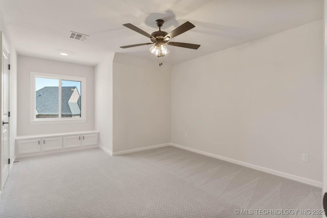 spare room featuring light carpet and ceiling fan