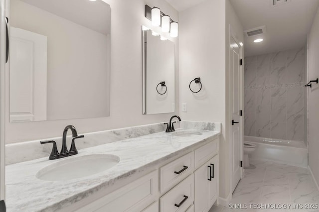 full bathroom with vanity, tiled shower / bath combo, and toilet