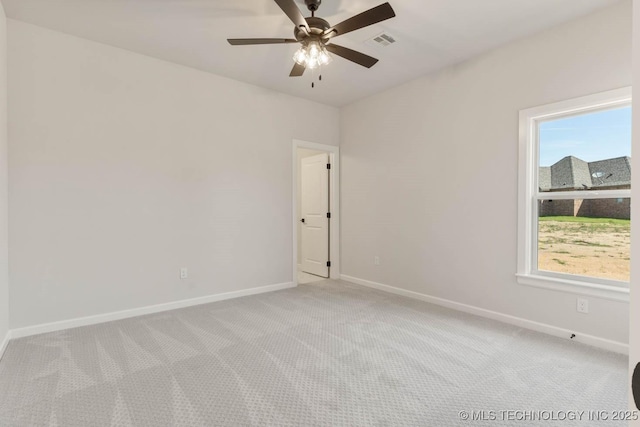 carpeted spare room with plenty of natural light and ceiling fan