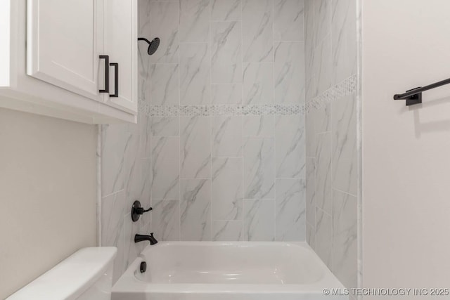 bathroom featuring tiled shower / bath combo and toilet