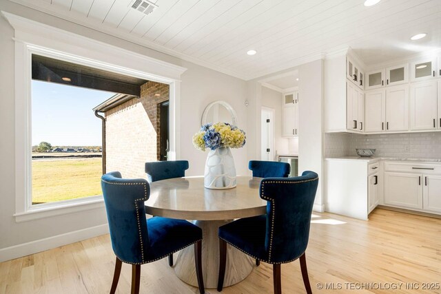 dining space with light wood-type flooring, wooden ceiling, and ornamental molding