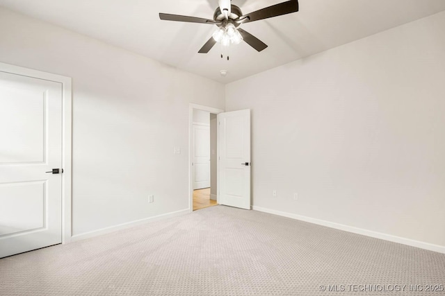 carpeted spare room with ceiling fan