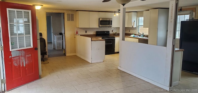 kitchen with backsplash, ceiling fan, white cabinetry, and black appliances