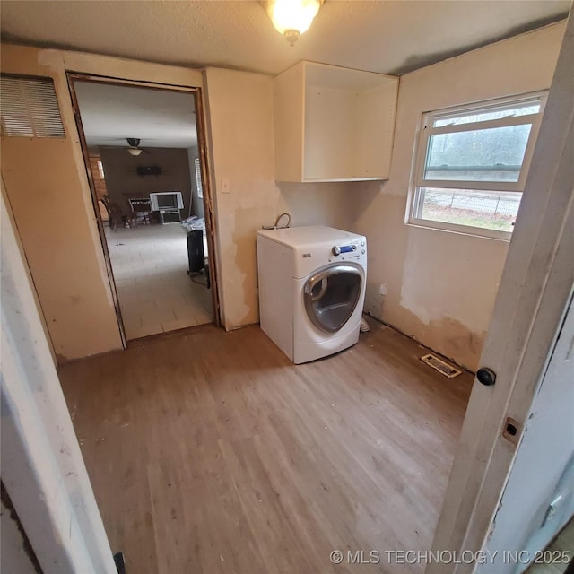 washroom with cabinets, washer / dryer, and light wood-type flooring