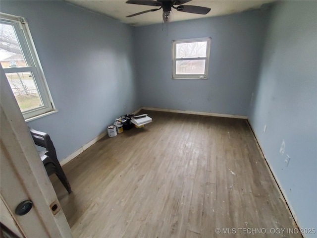 spare room featuring ceiling fan, a healthy amount of sunlight, and light wood-type flooring