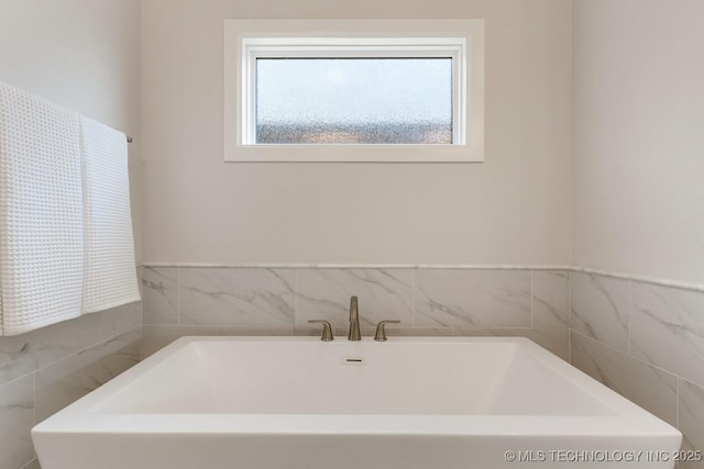 full bathroom with a freestanding bath and tile walls